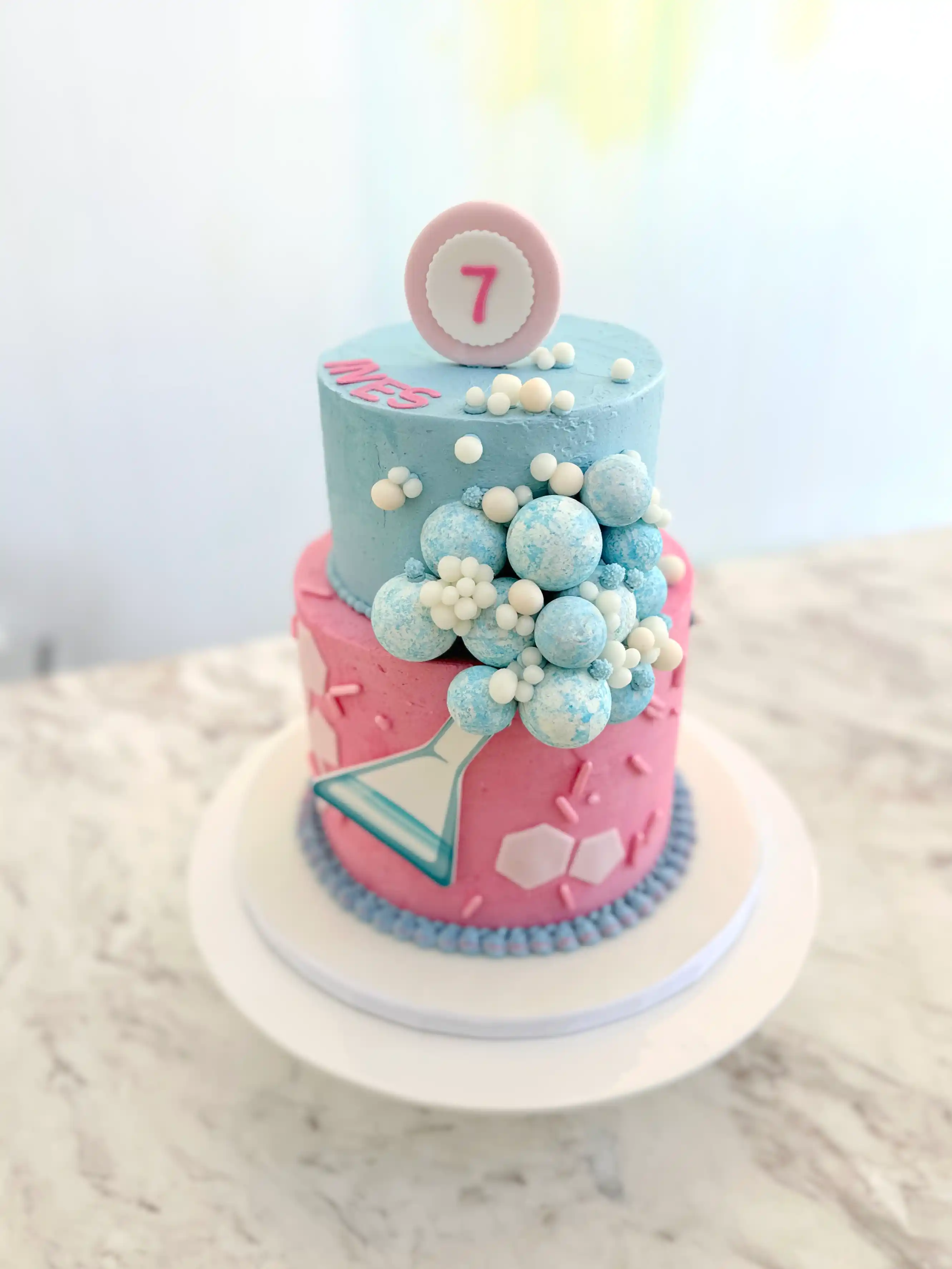 Modern pastel birthday cake for girl with chocolate spheres and number topper, stylish designer cake in cyprus