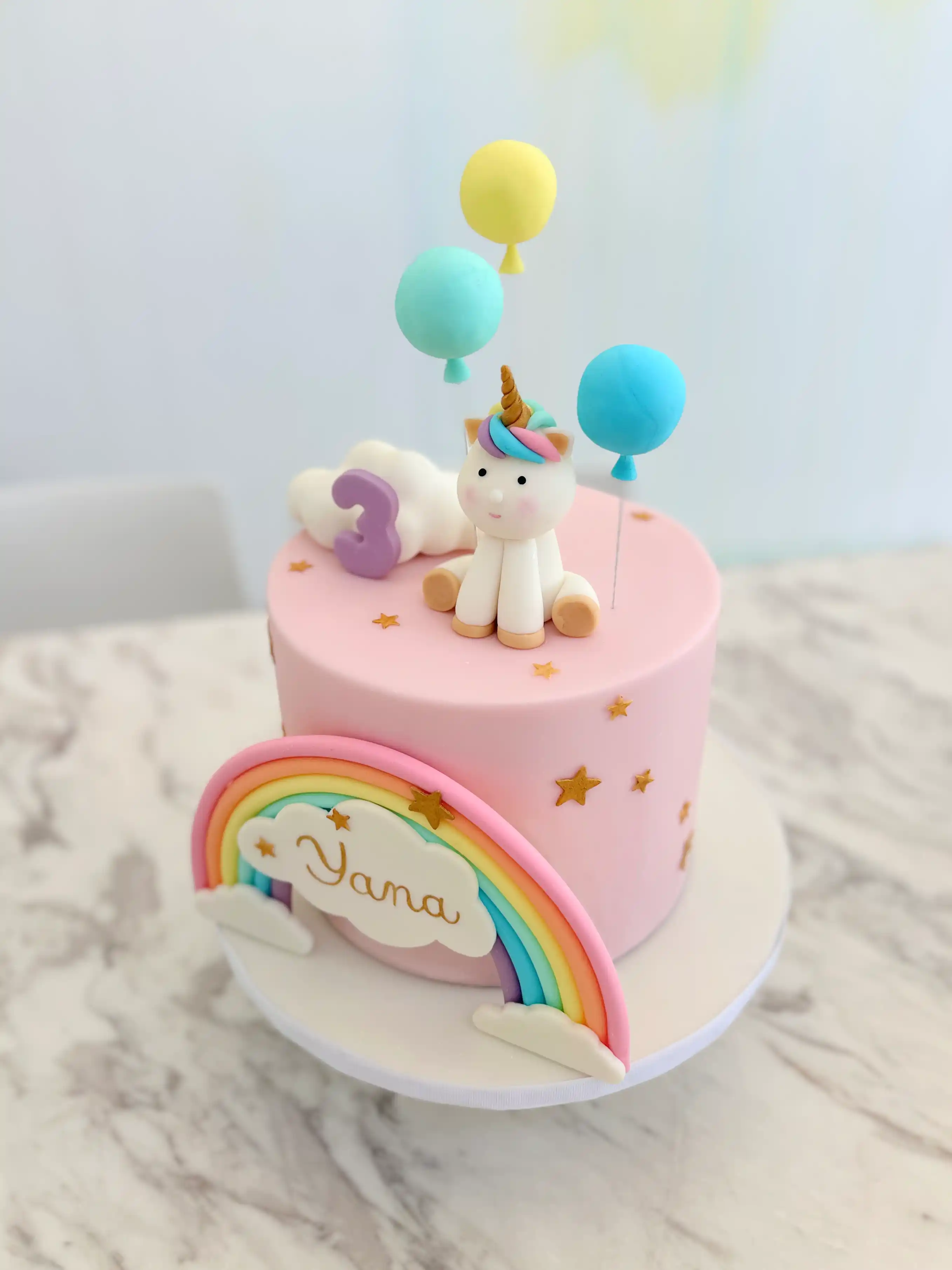 Pastel unicorn birthday cake for girl with rainbow and balloons, personalised whimsical cake design in cyprus