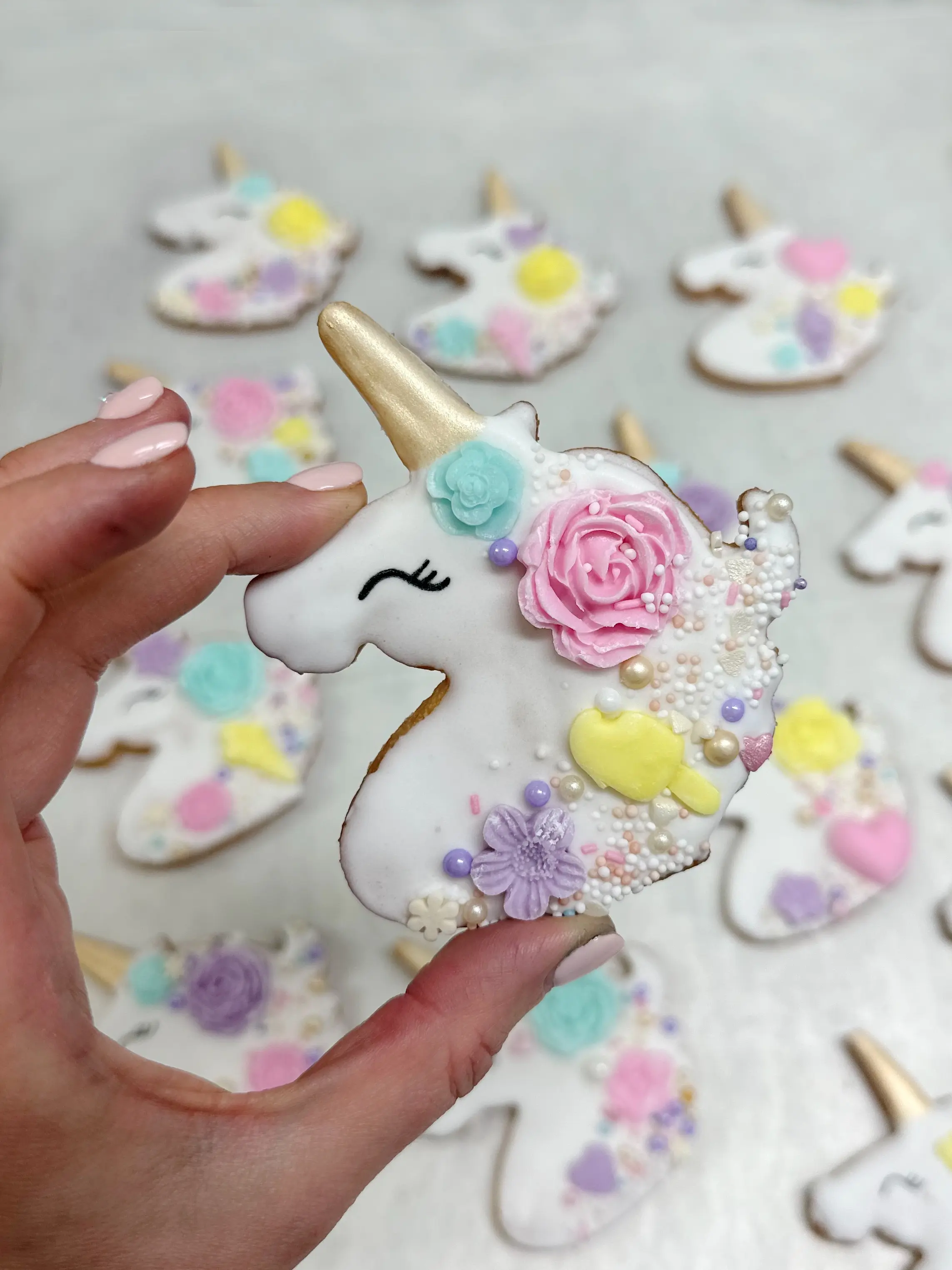 Handcrafted unicorn cookies with pastel royal icing, floral details and gold horn, bespoke themed treats available in limassol cyprus