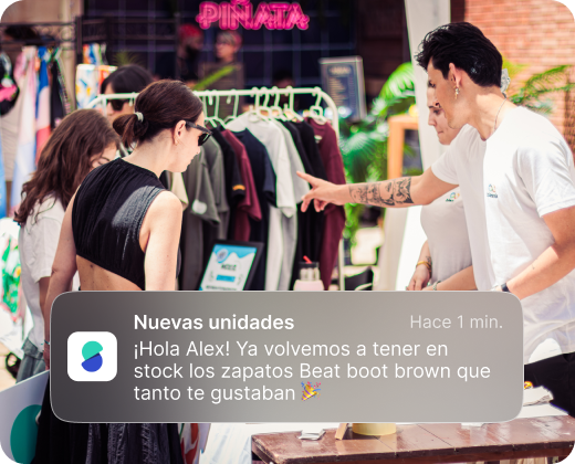 Two men and two women browsing clothes on a rack outside a store with a neon 'PINATA' sign in the background.
