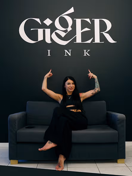 Klaudia in the studio with the Giger Ink logotype displayed on the wall