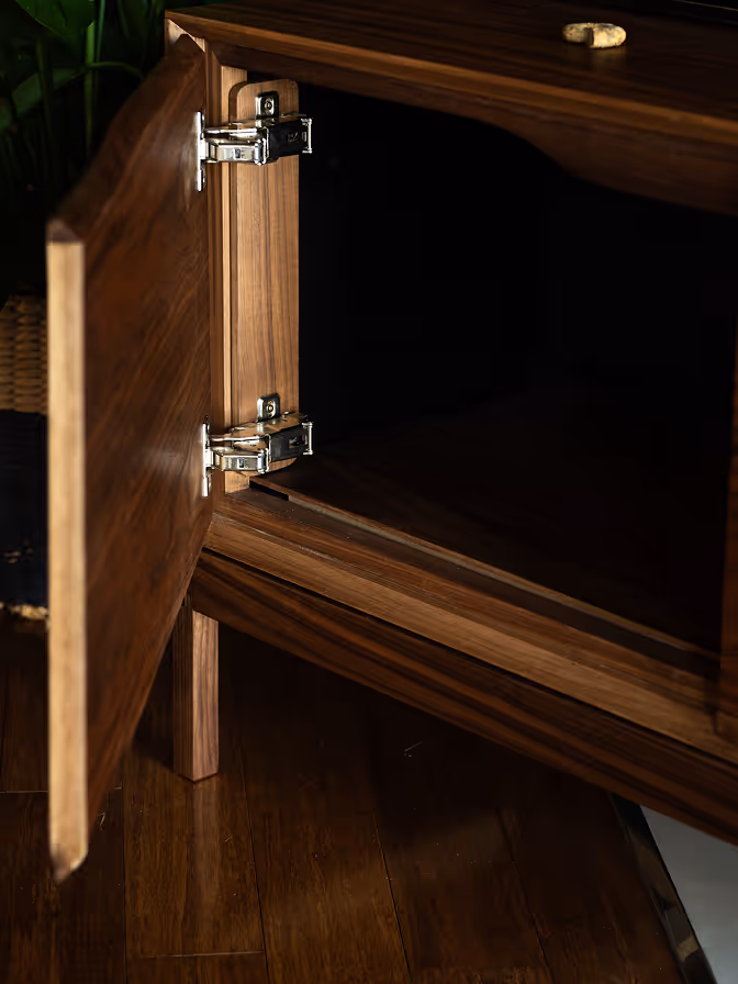 Detail of the Lucca Organic cabinet showing the hinges and interior, in walnut veneer with solid walnut edges