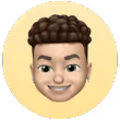 3D emoji-style face of a smiling young man with curly brown hair and light skin on a yellow circular background.