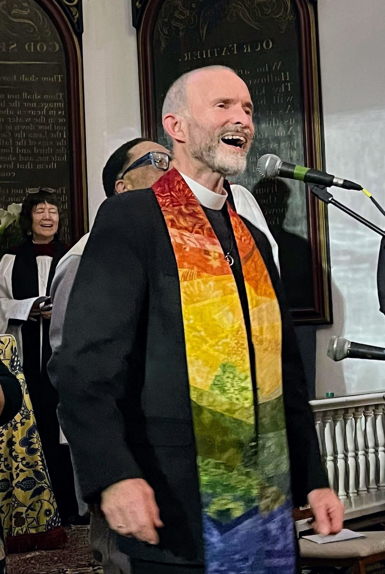 Rev. Fred Small singing into a microphone at the Green Light for Climate Justice event