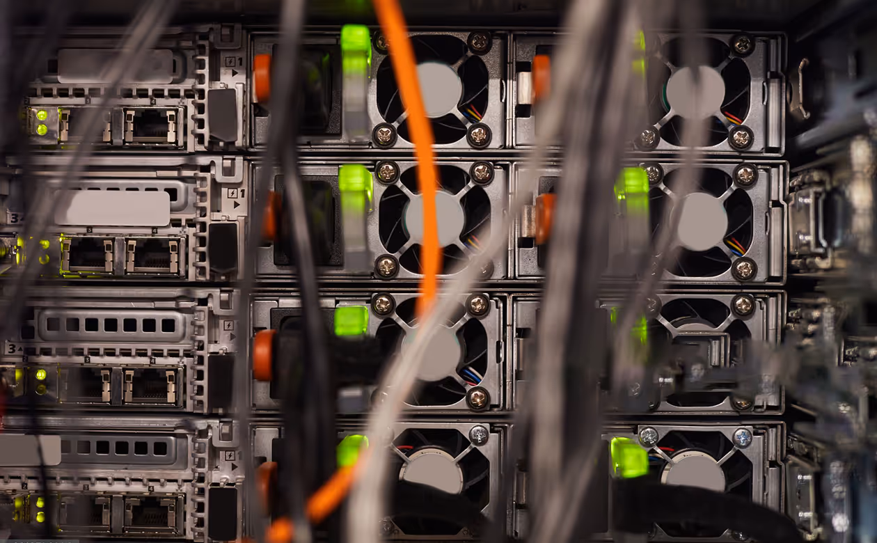 Close-up of server racks with network cables and green indicator lights in a data center.