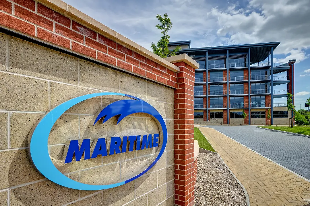 Maritime Transport logo on a brick wall in front of office building