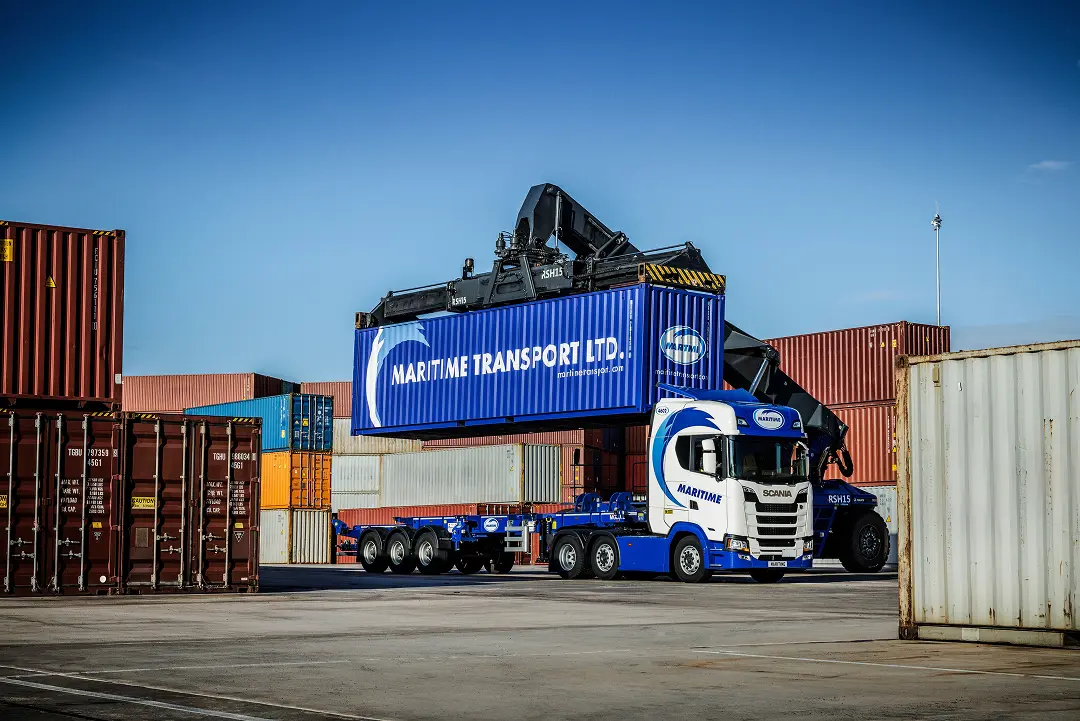 Reach stacker placing a container onto a Maritime Transport intermodal truck