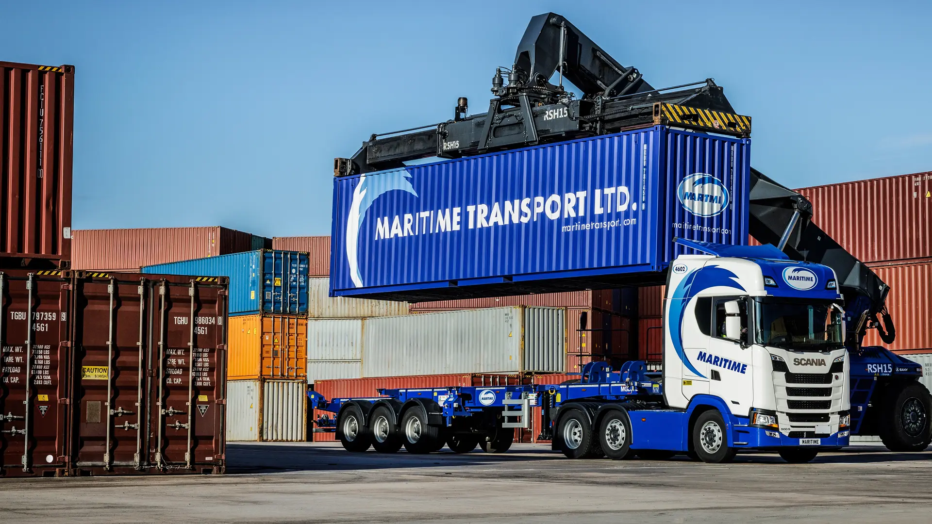 Reach stacker placing a container onto a Maritime Transport intermodal truck