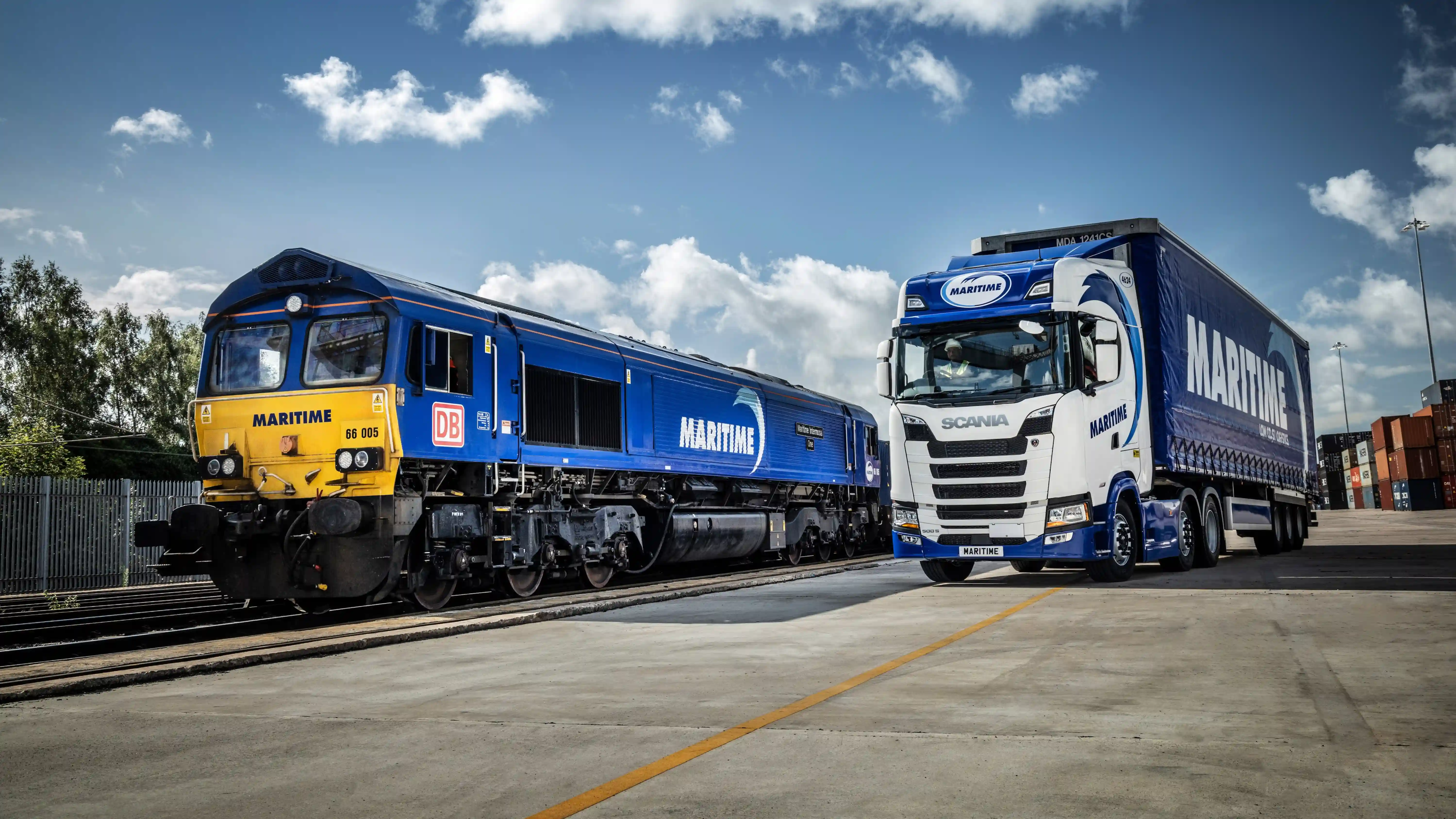 Train and curtainsided truck alongside eachother