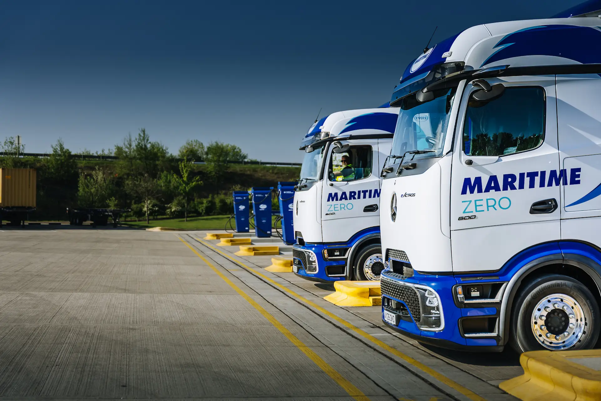 A row of Maritime ZERO eHGVs and chargers.