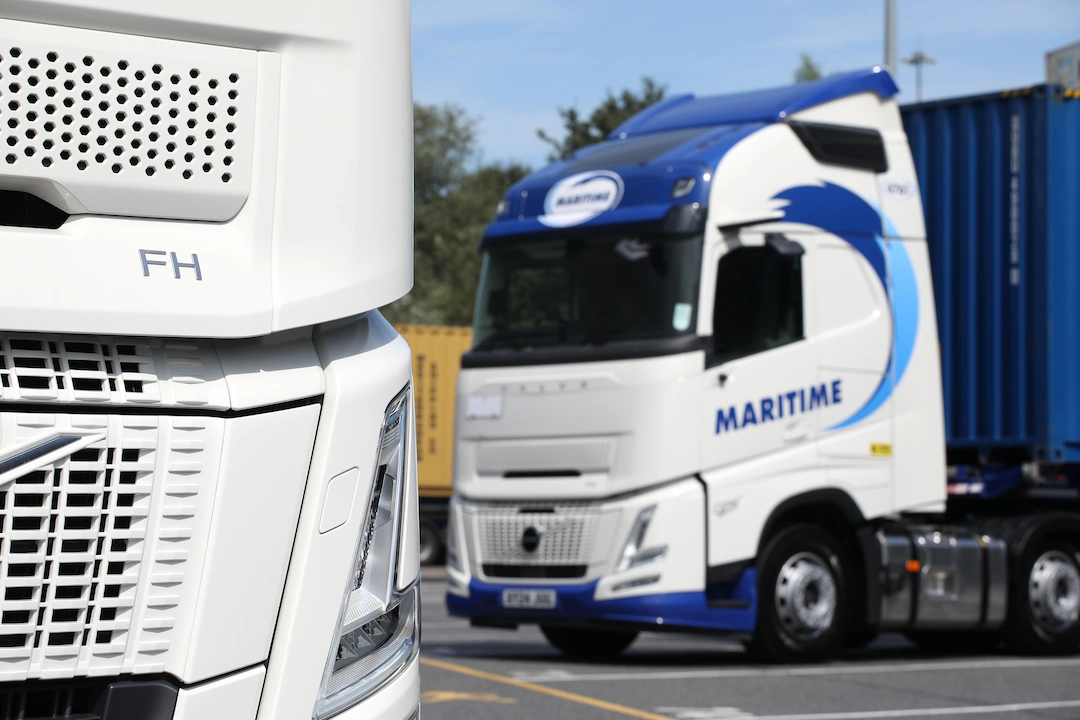 A close up of an HGV grill with a Maritime Transport container vehicle in the background.