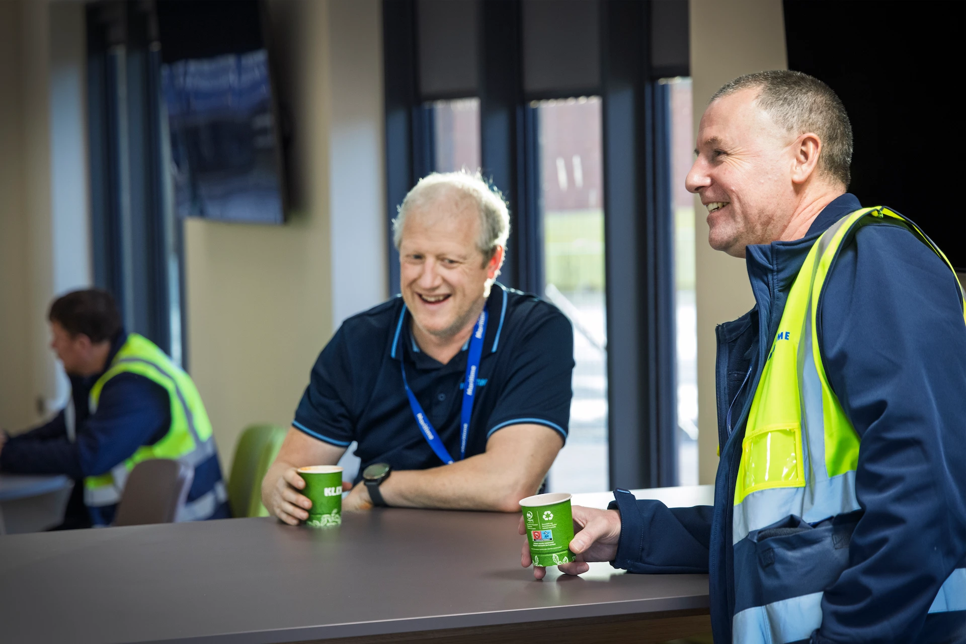 Two Maritime Transport drivers taking a break with coffees.