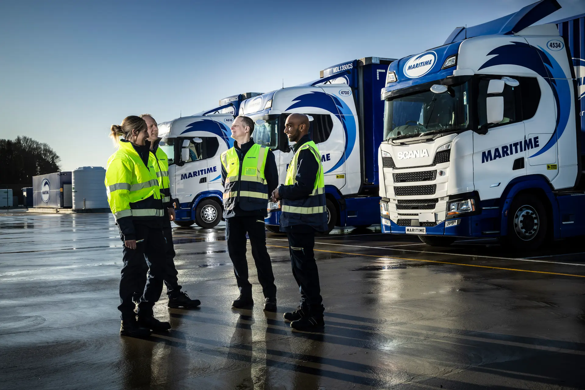 Four drivers have a conversation in front of Maritime trucks