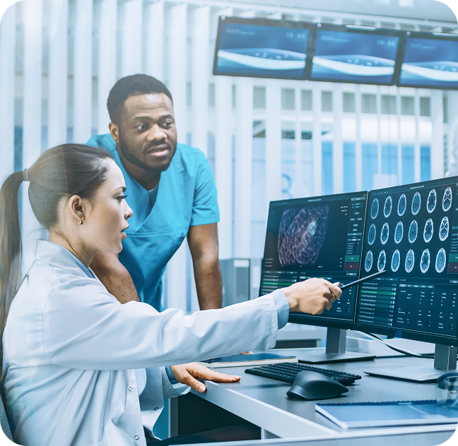 Two medical professionals analyzing brain scan images on dual monitors in a clinical setting.