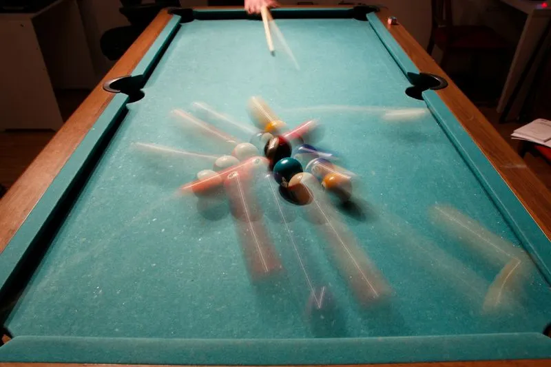 A pool table with a bunch of pool balls on it.