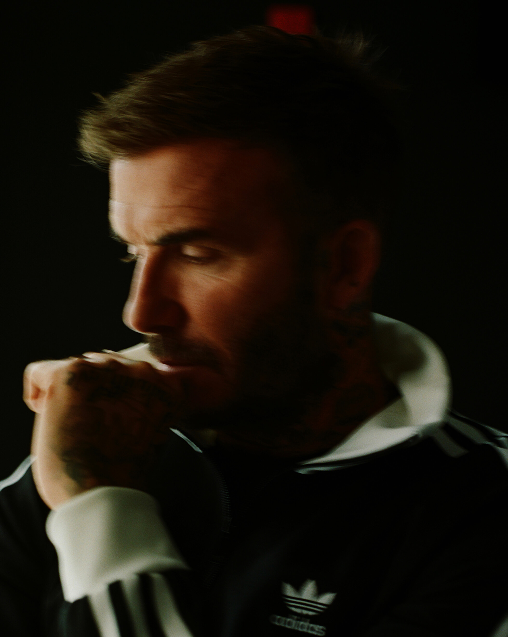 Side view of David Beckham wearing a black Adidas jacket