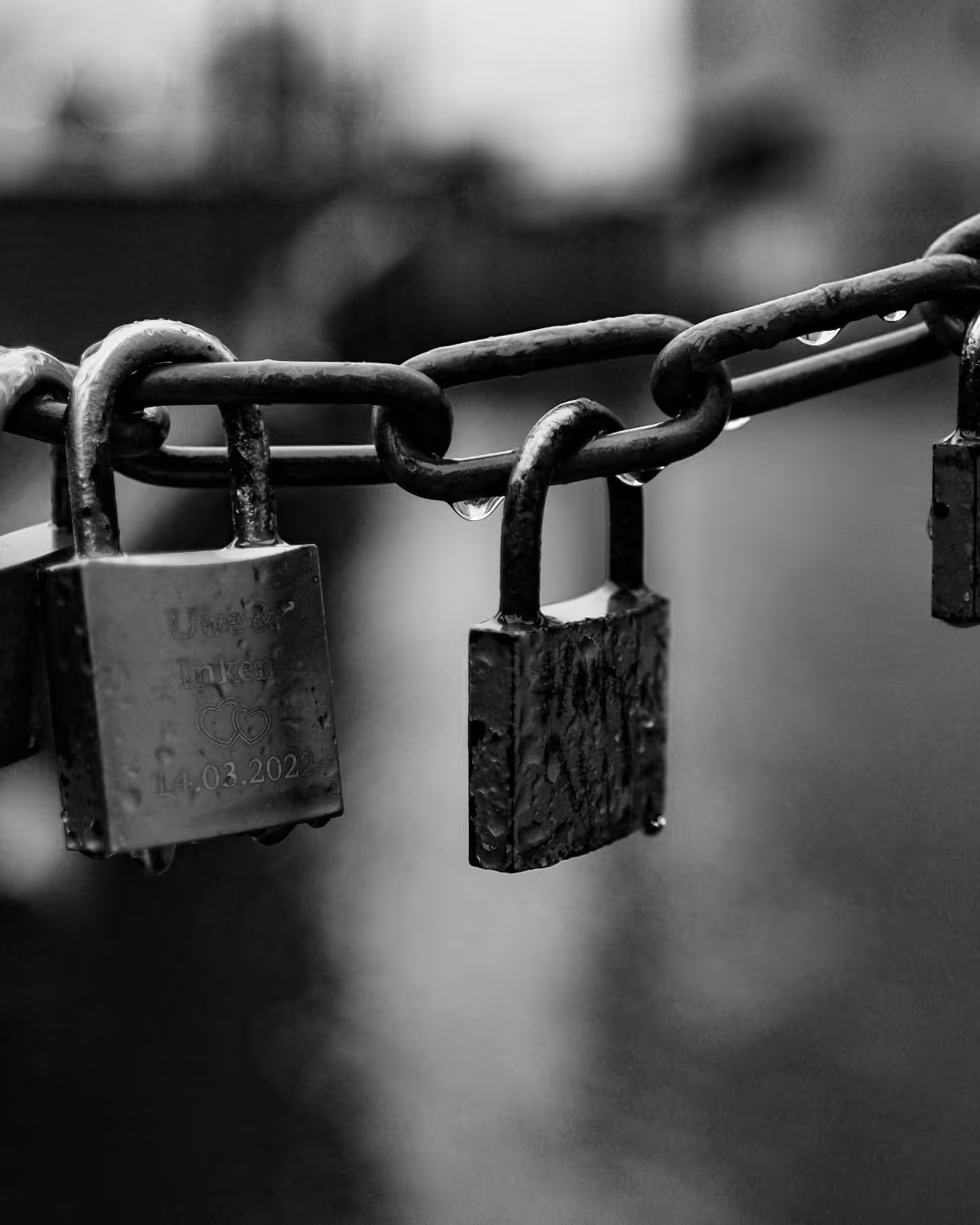 A chain with a series of padlocks hanging from it,