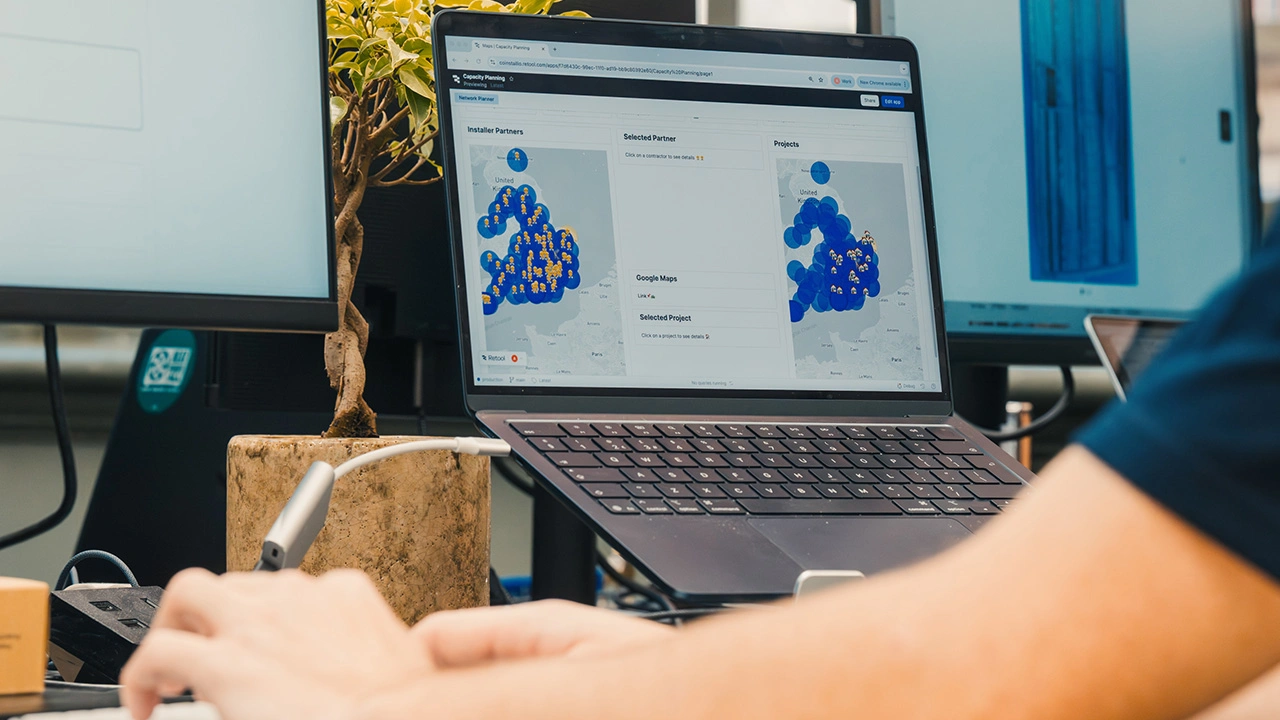 Person working on a laptop with a map-based capacity planning dashboard open on the screen.