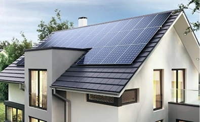Modern house with a rooftop covered by solar panels under a clear sky.