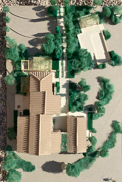 Bird's-eye view of a physical architectural model showing the house layout and green spaces.