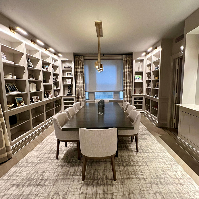 Custom walk-in closet renovation in a NYC residence featuring bespoke wood cabinetry, center island storage, and modern lighting.