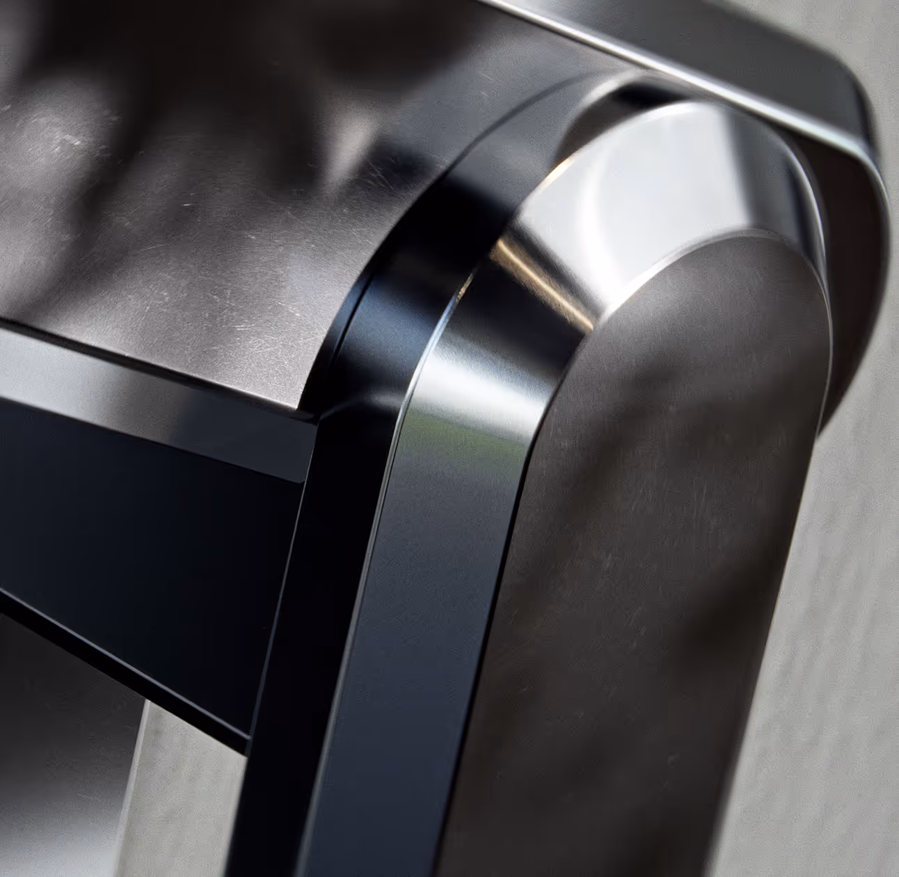Close-up of a metallic hinge connecting parts with brushed metal and black finish details.
