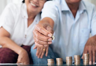 Idoso montando pilha de moedas