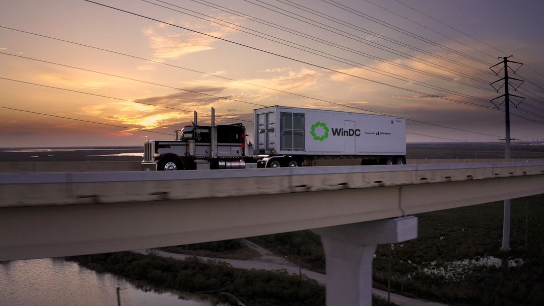 WinDC portable data centre being transported by truck at sunset