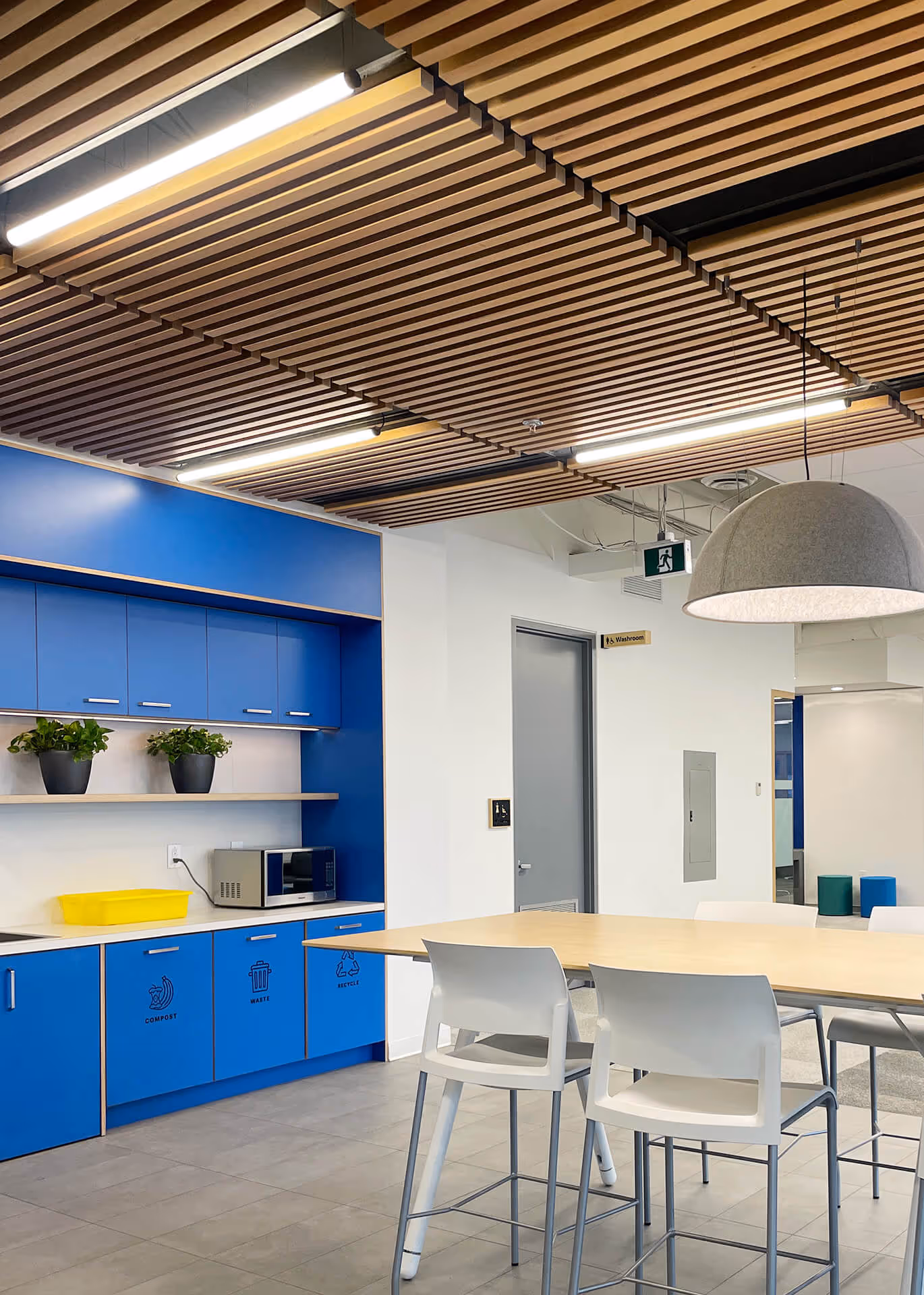 breakroom with blue cabinetry and large gray dome pendant lighting.