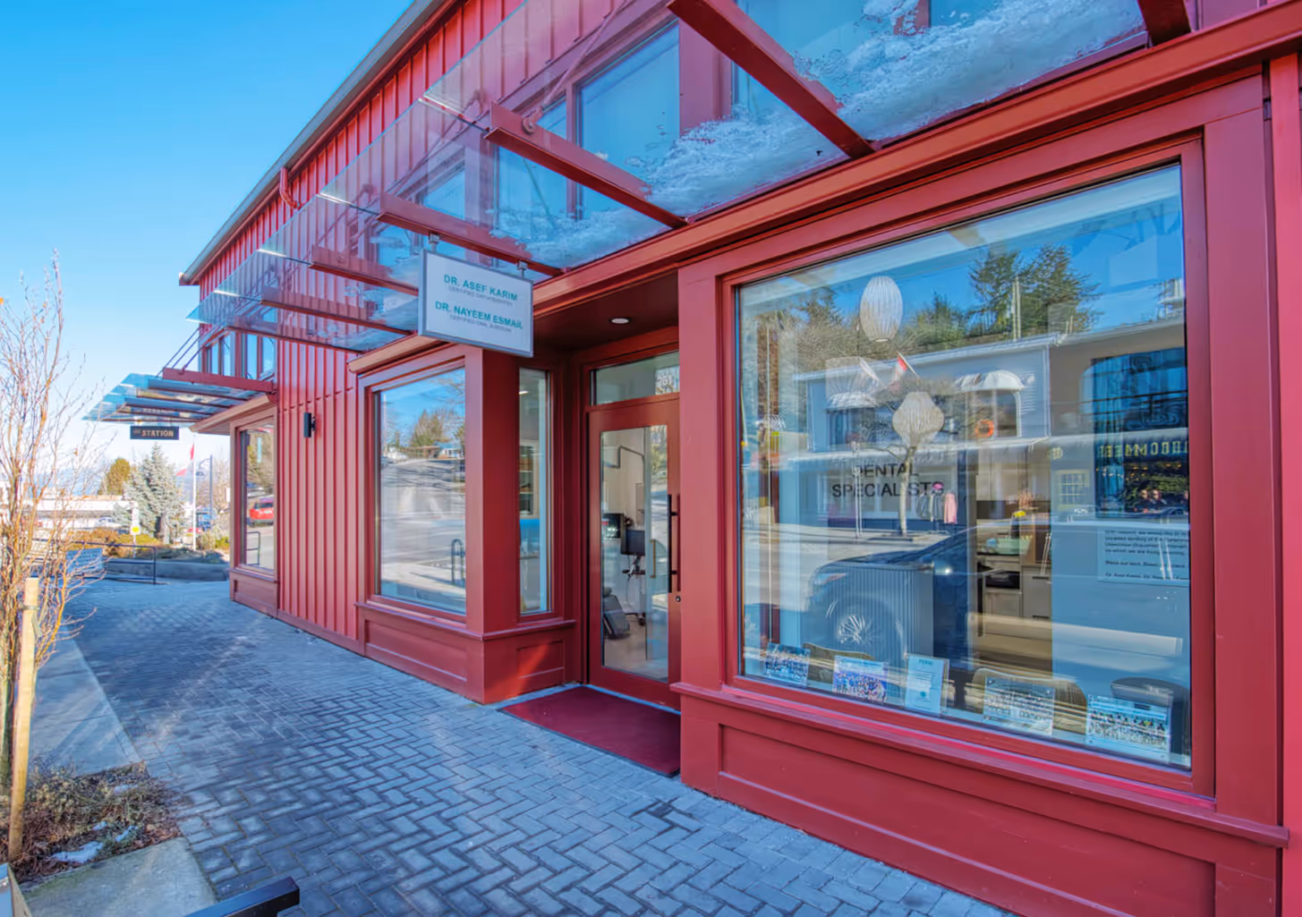 Exterior view of Coast Dental Specialists clinic with red facade and glass entrance