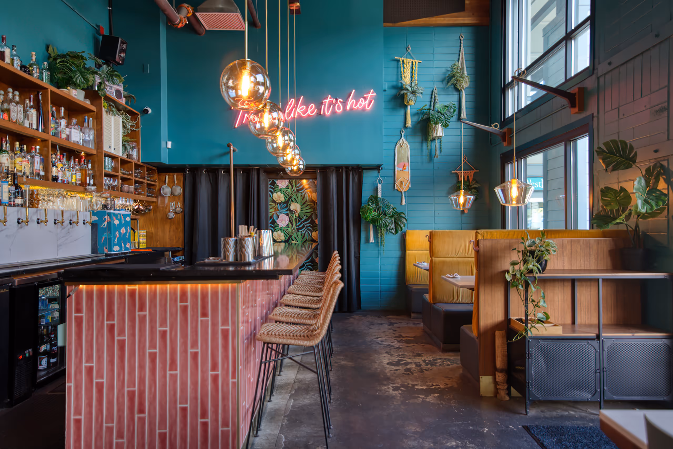 Bar area featuring a pink neon sign and hanging gold globe lights.