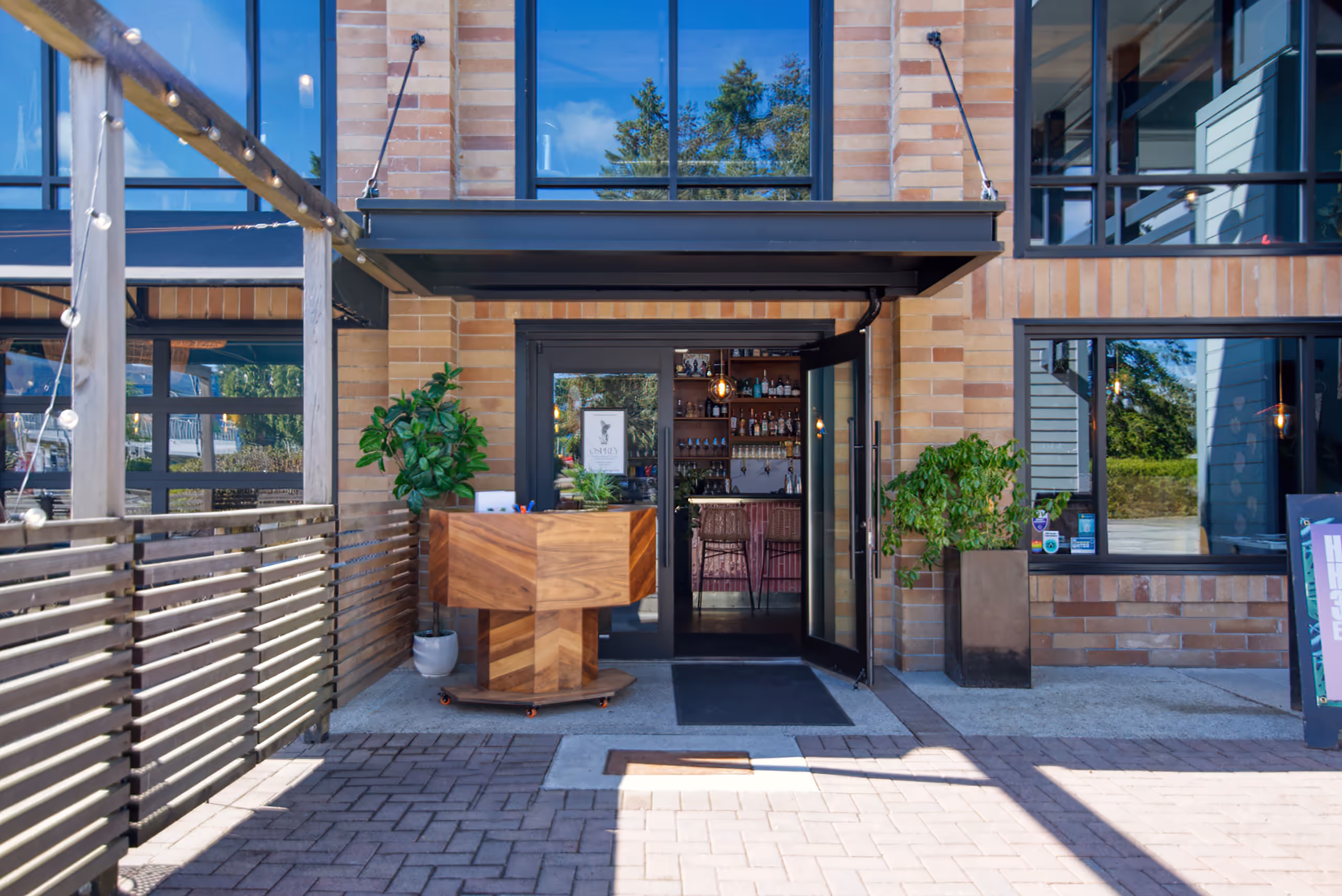 El Segundo restaurant entrance with a geometric wooden host stand and glass doors.