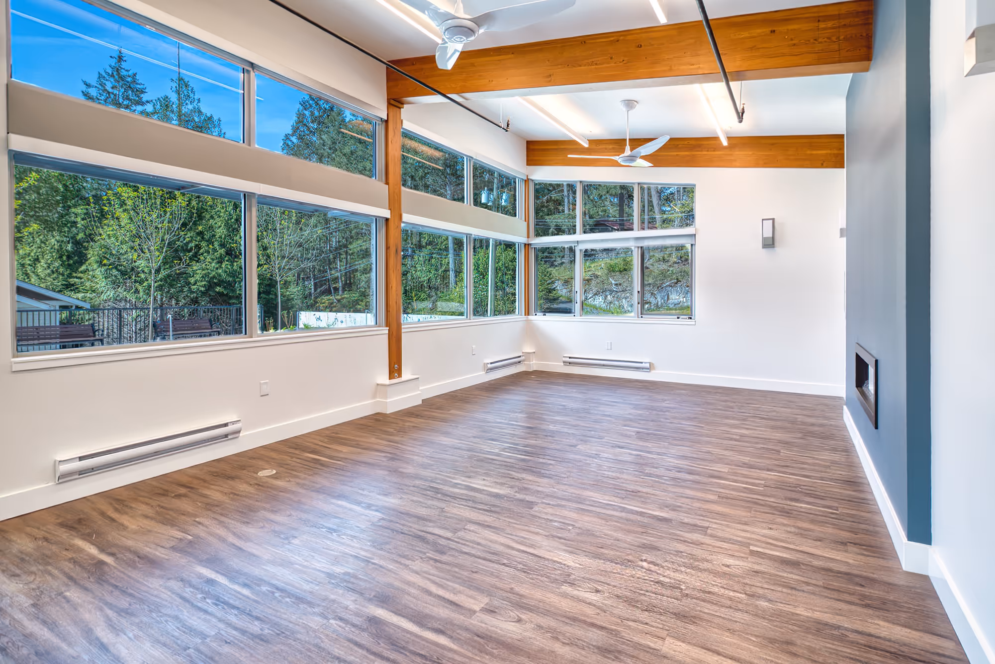 Large open interior at Lily Lake Place Seniors Housing with wood beams and full-height windows.