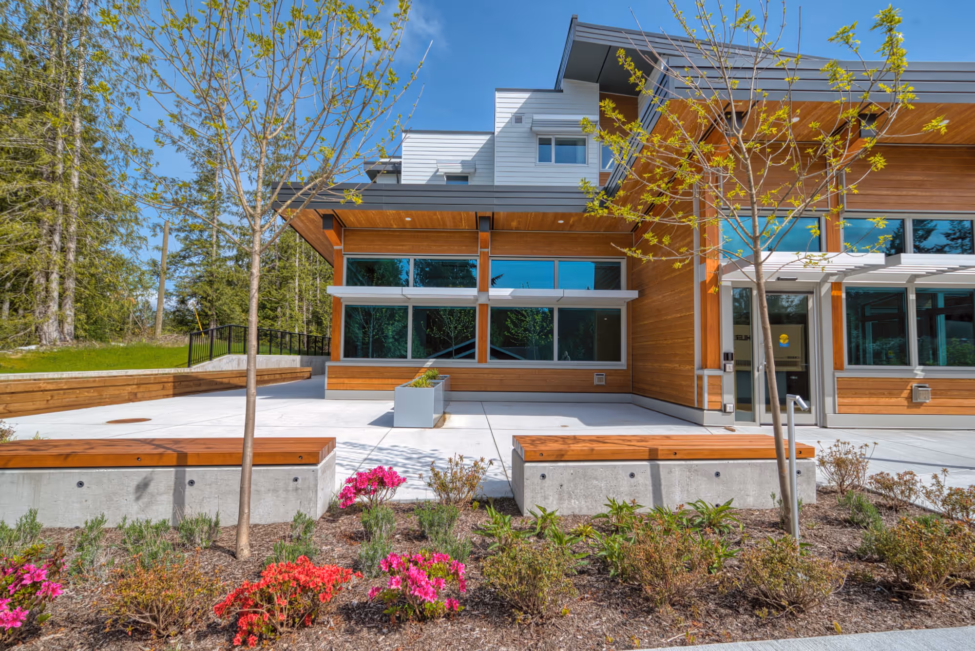 Exterior of Lily Lake Place Seniors Housing with wood siding and landscaped courtyard seating.