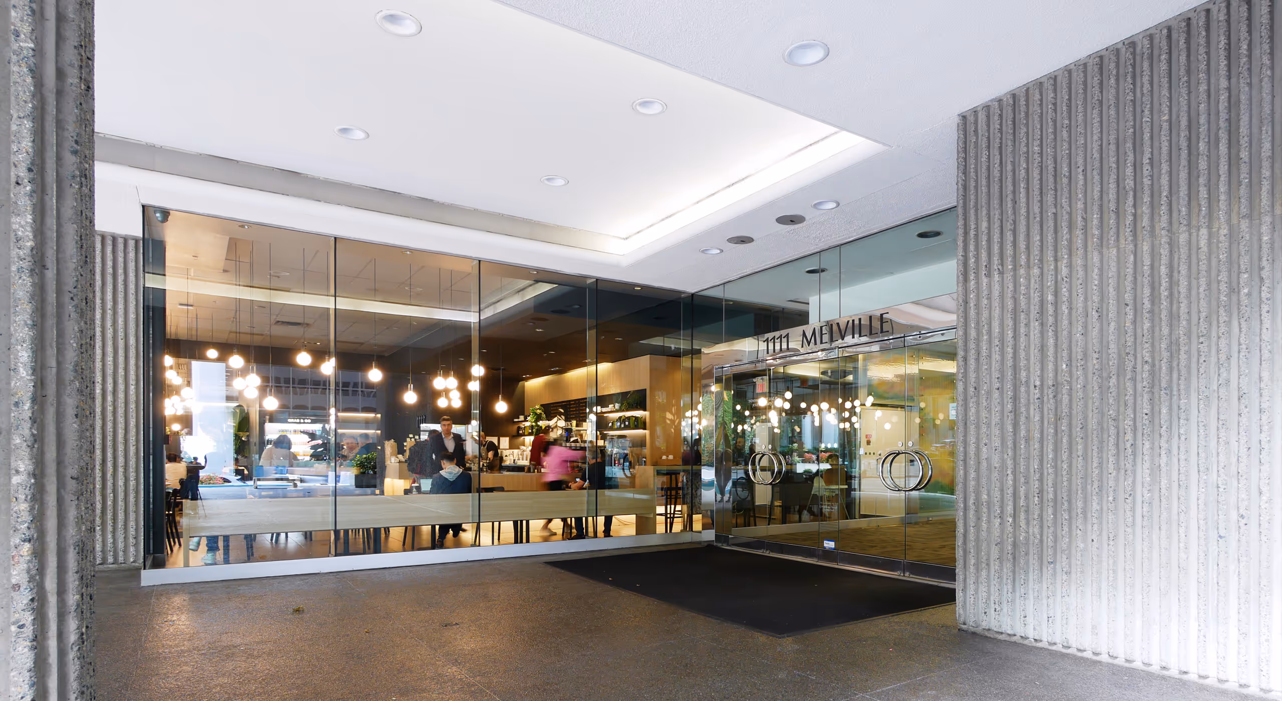 Glass entry to café area at 1111 Melville multi-tenant office building in Vancouver.