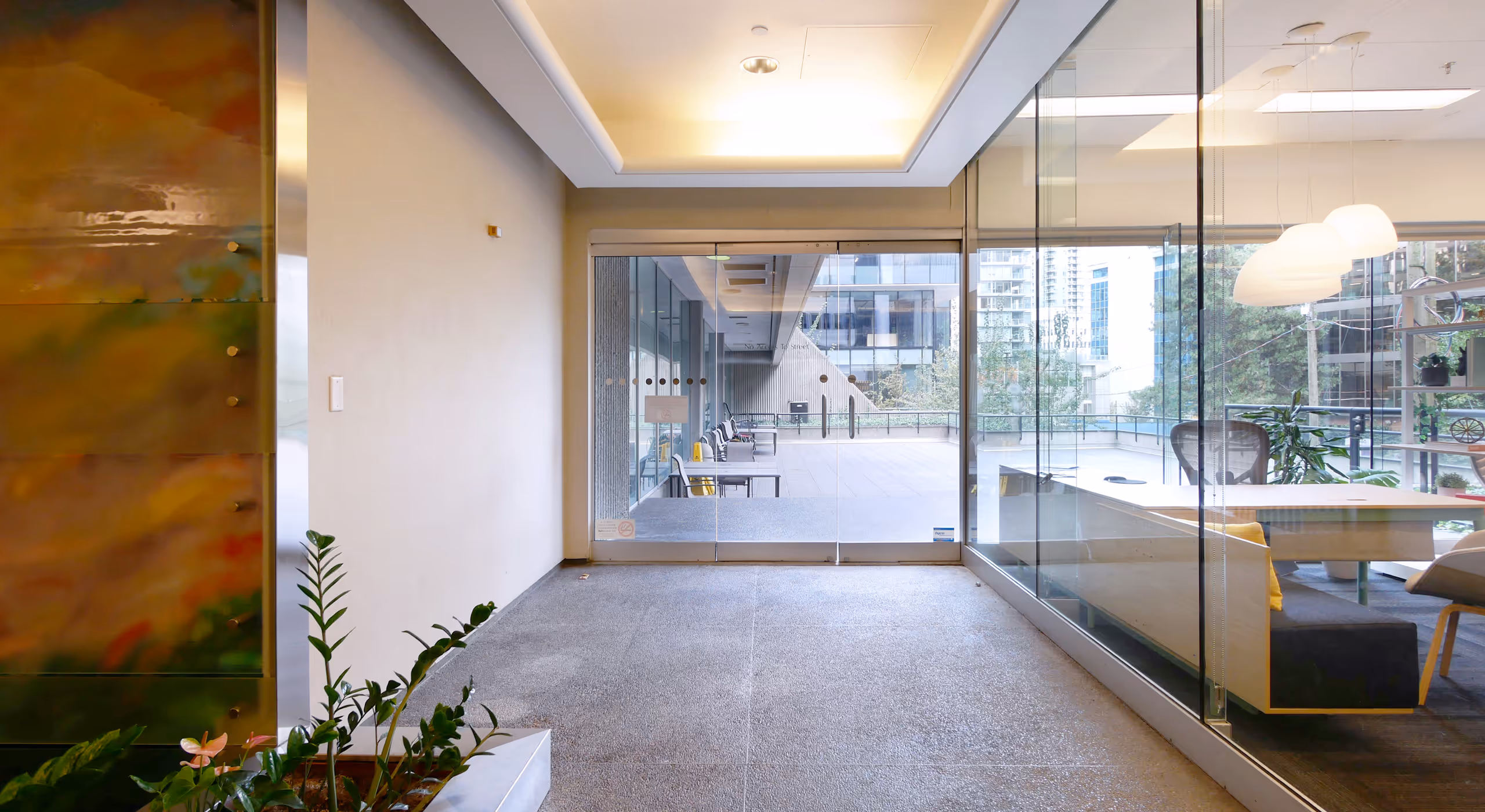 Interior circulation space at 1111 Melville commercial tower with glass walls and exterior access.