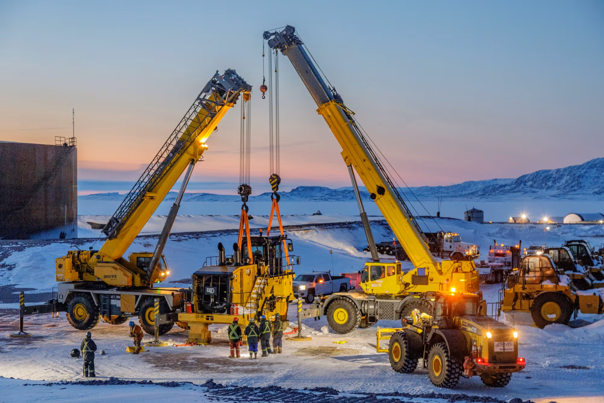 Heavy equipment lift at Goose Lake industrial site with cranes positioning machinery at dusk.