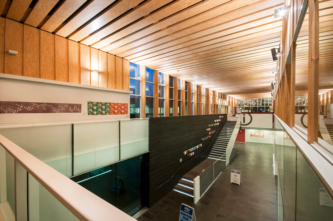 Interior gallery space at North Vancouver City Hall Redevelopment with timber finishes and display wall.