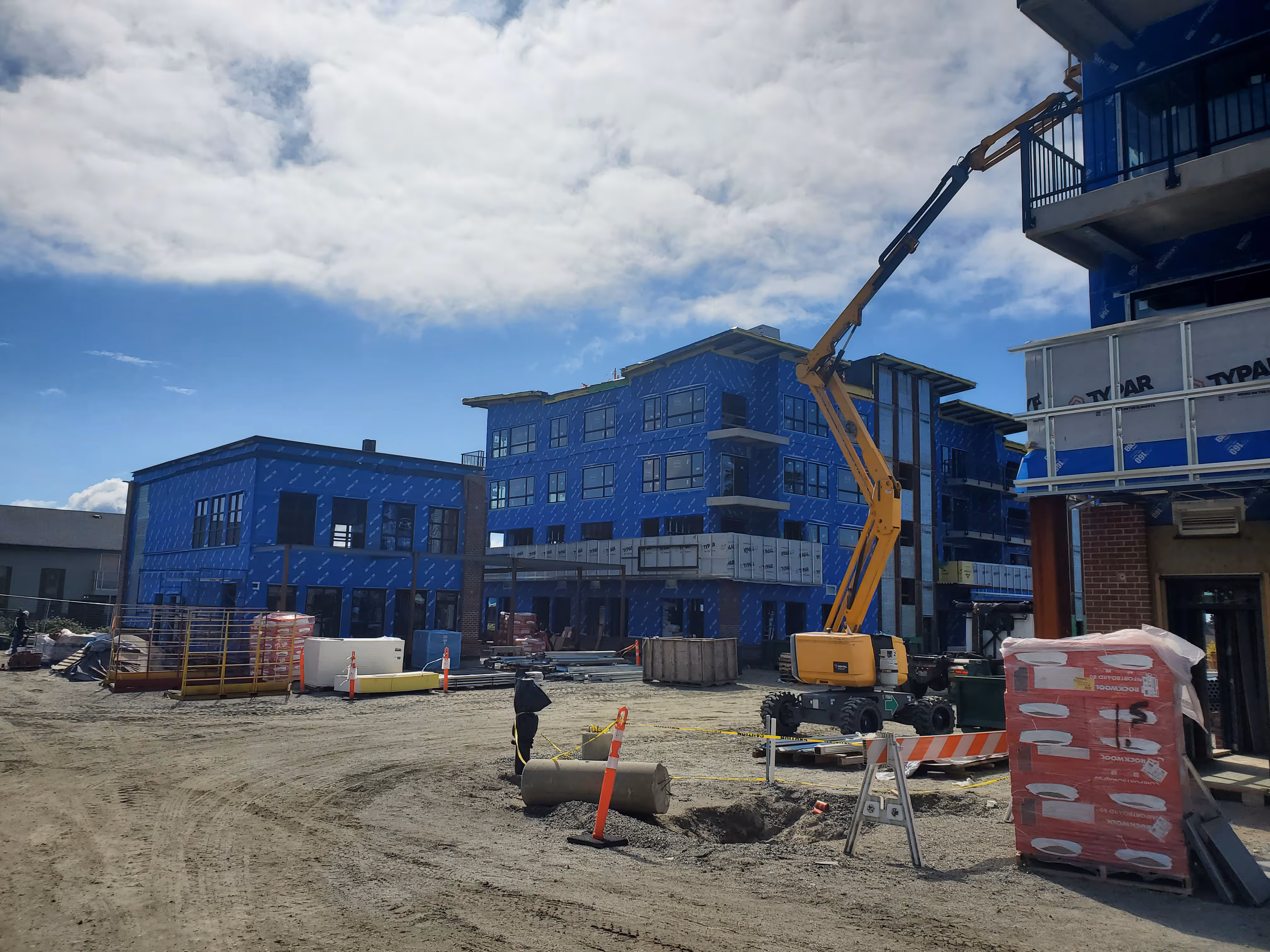 Construction phase of Venture Industrial Village with building envelope installation and electrical infrastructure development.