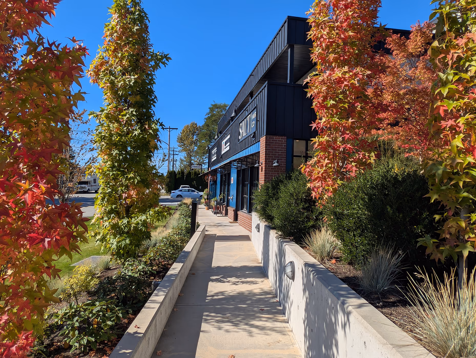 Retail walkway at Venture Industrial Village framed by landscaping and contemporary building facade.