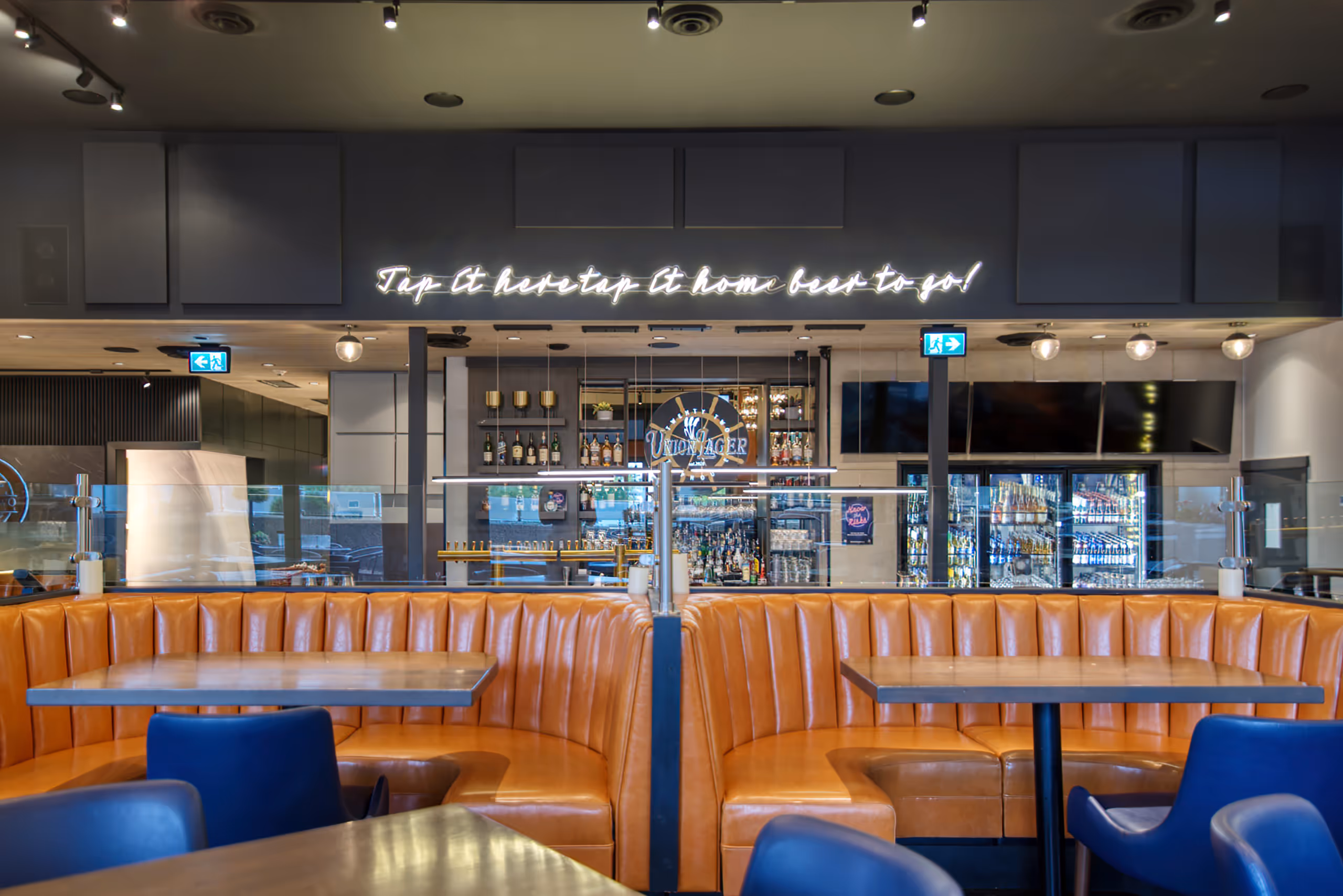 Bar interior with illuminated signage and accent lighting at Twenty Two Taphouse