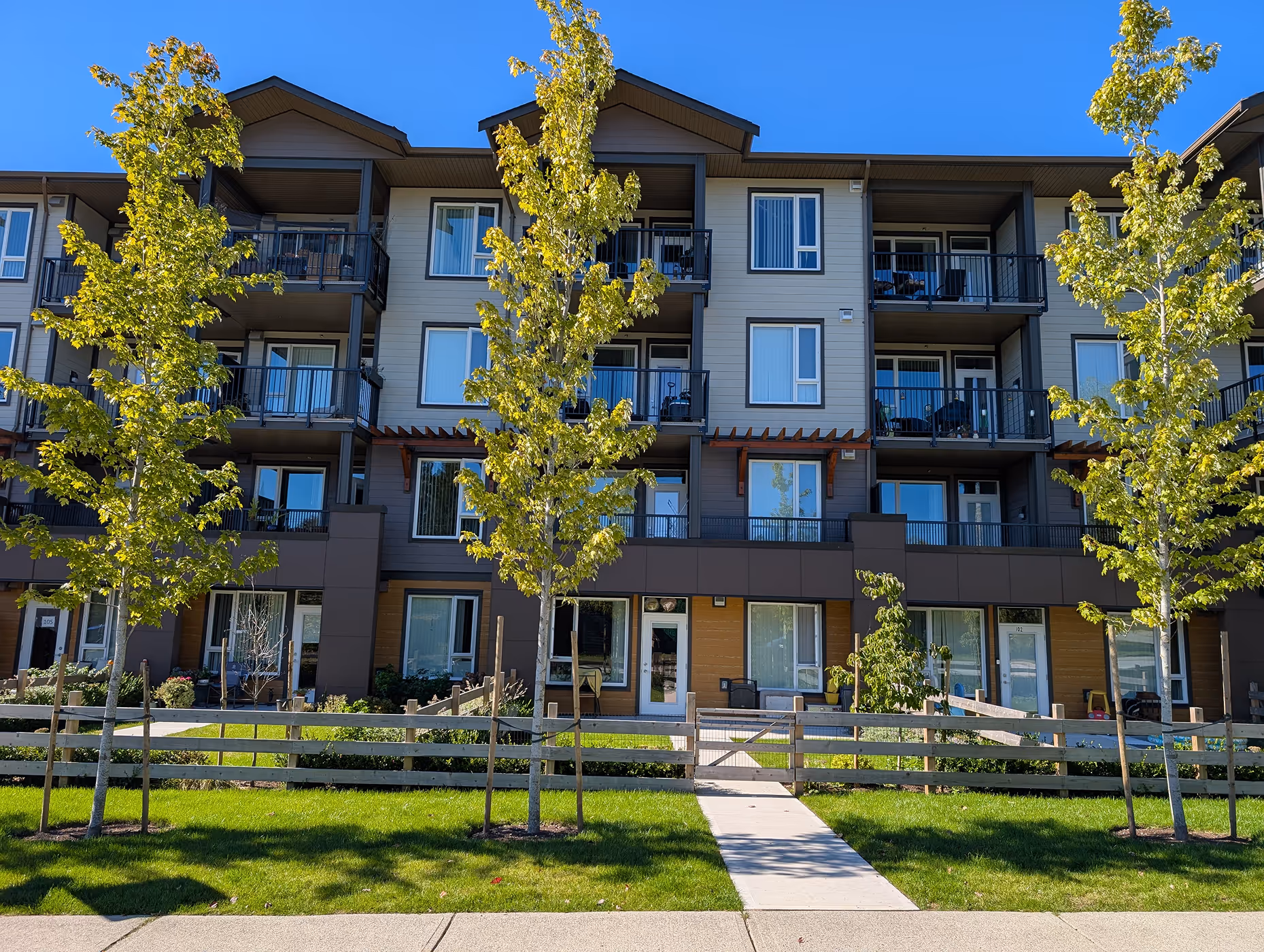 Front elevation of Shaw Road Affordable Housing in Gibsons, BC with landscaped courtyard and multi-storey residential building