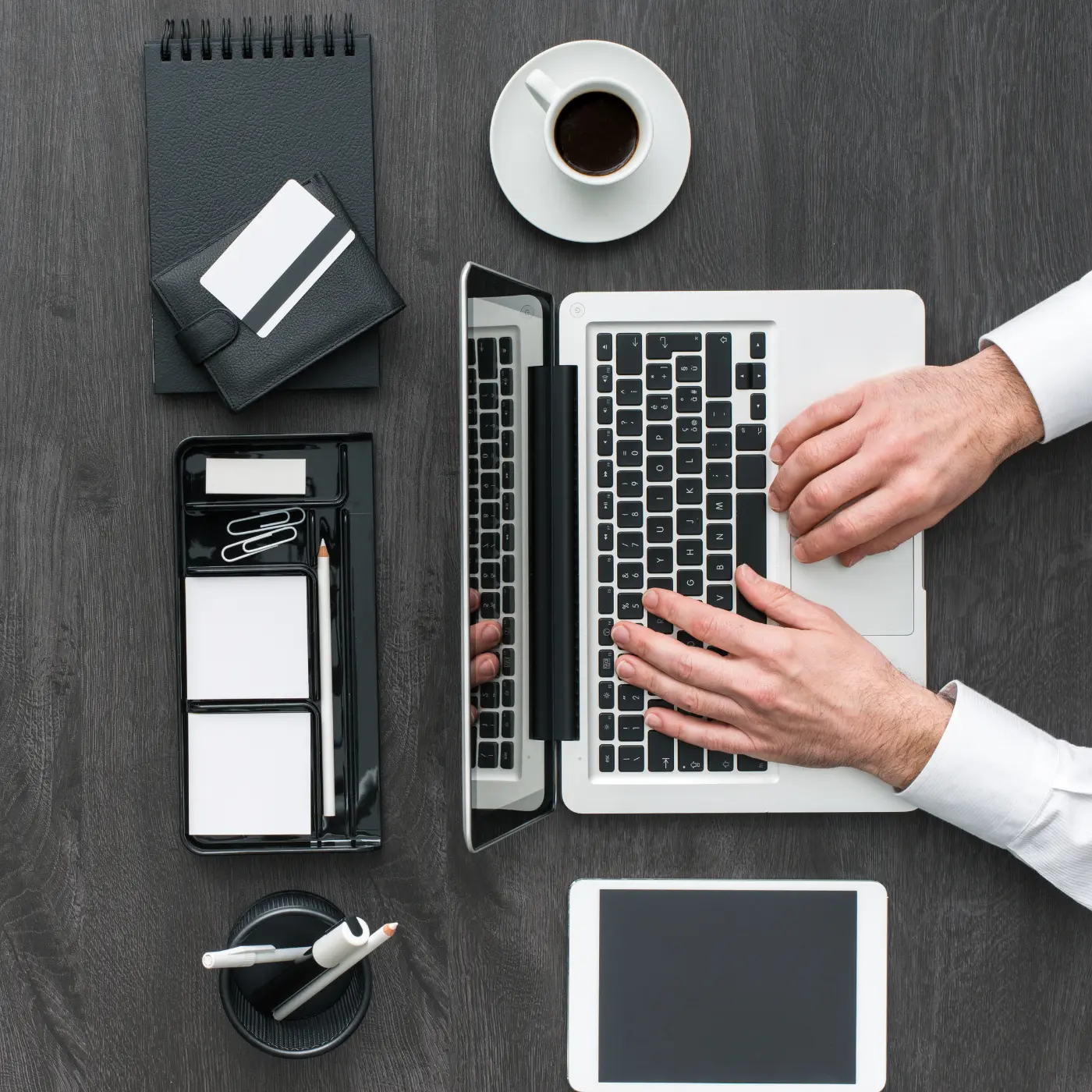 Persona trabajando con una laptop, sobre su escritorio se ven herramientas personales.