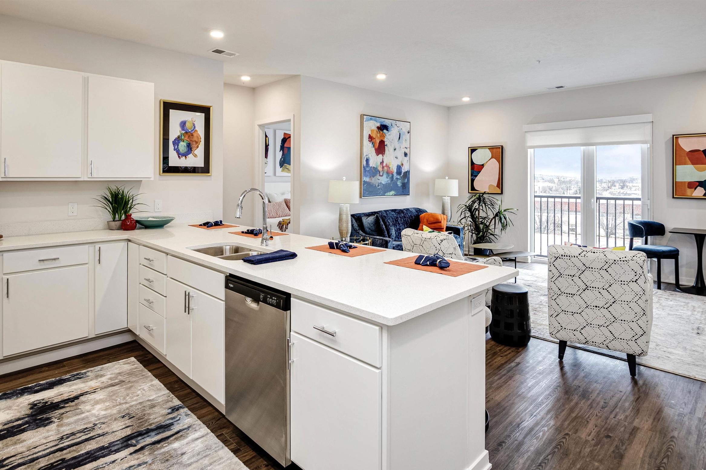 Kitchen with white countertops overlooking the living room