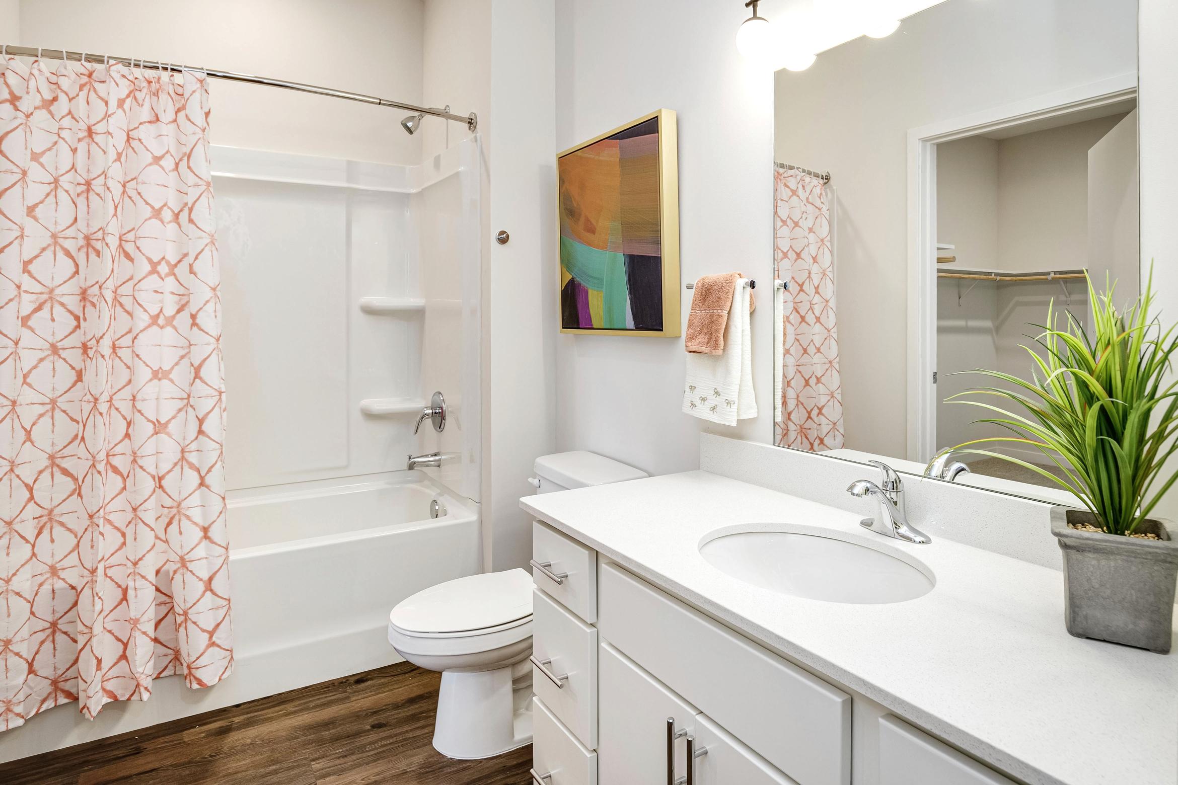bathroom vanity, mirror, and shower/tub combo
