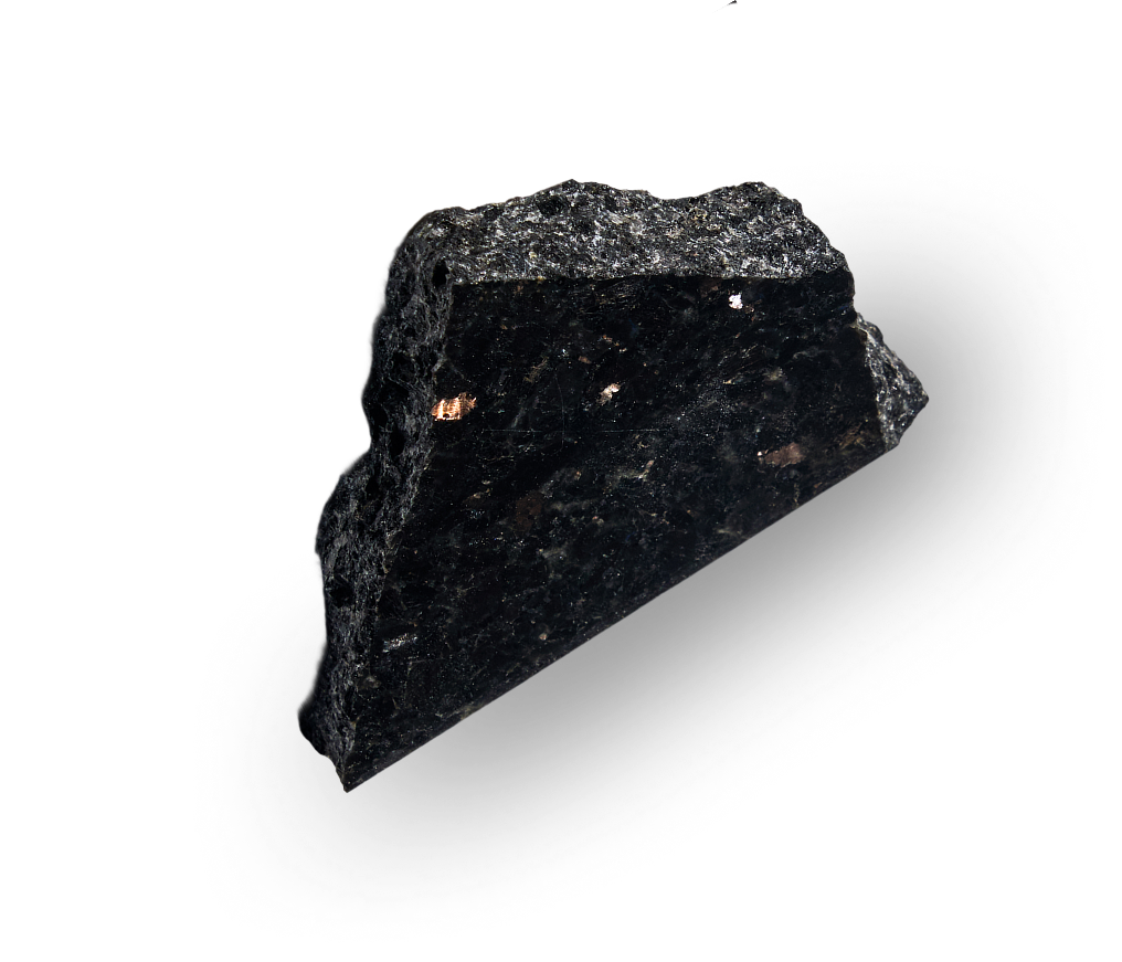 Polished black granite rock showing a textured surface with small reflective mineral spots.