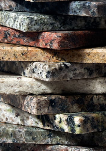 Stack of rectangular polished granite slabs in various colors and patterns.