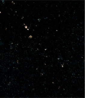 Black textured surface with scattered reflective gold-colored specks.