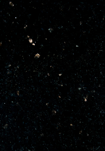 Close-up of black granite with small reflective mineral flecks scattered across the surface.