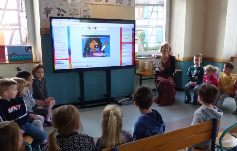 Des enfants de maternelle qui regardent une vidéo sur le TBI avec la maîtresse.